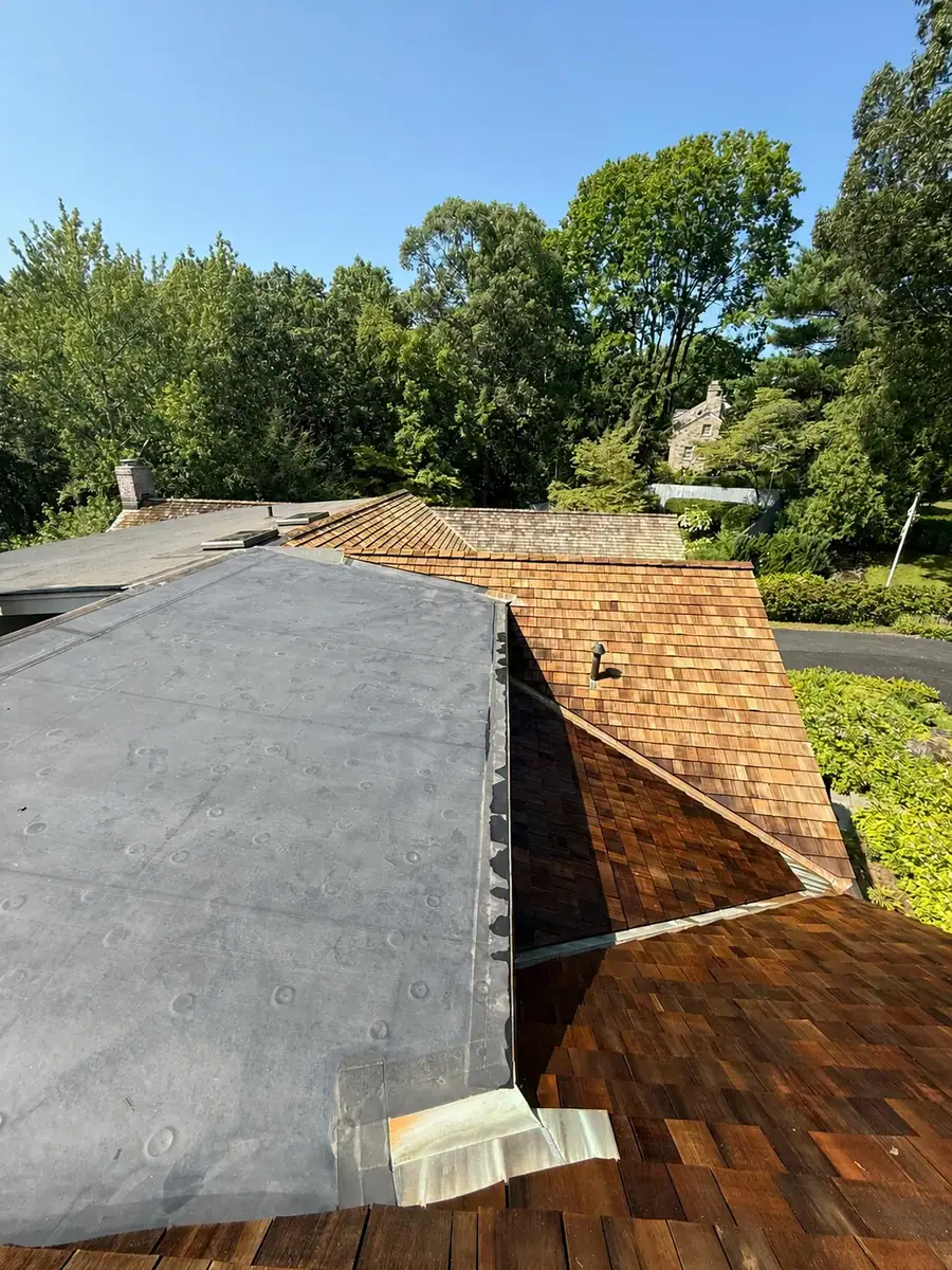Completed cedar shake roof with a clear driveway background
