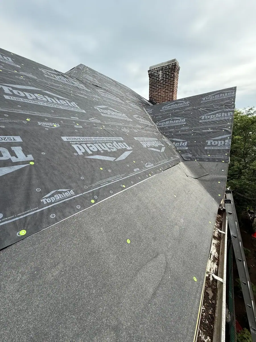 Waterproofing underlayment installed around a chimney during roof replacement in Mamaroneck