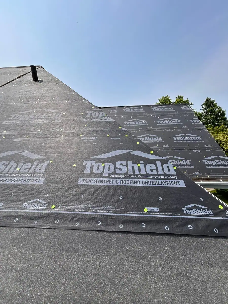 Synthetic roofing underlayment secured before new shingles