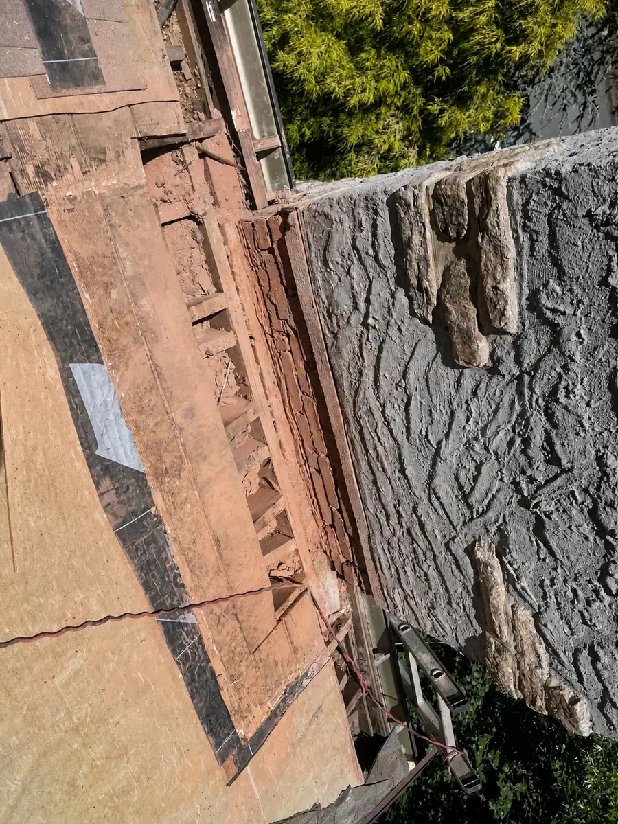 Existing deteriorated chimney-side roof decking before restoration in New Rochelle