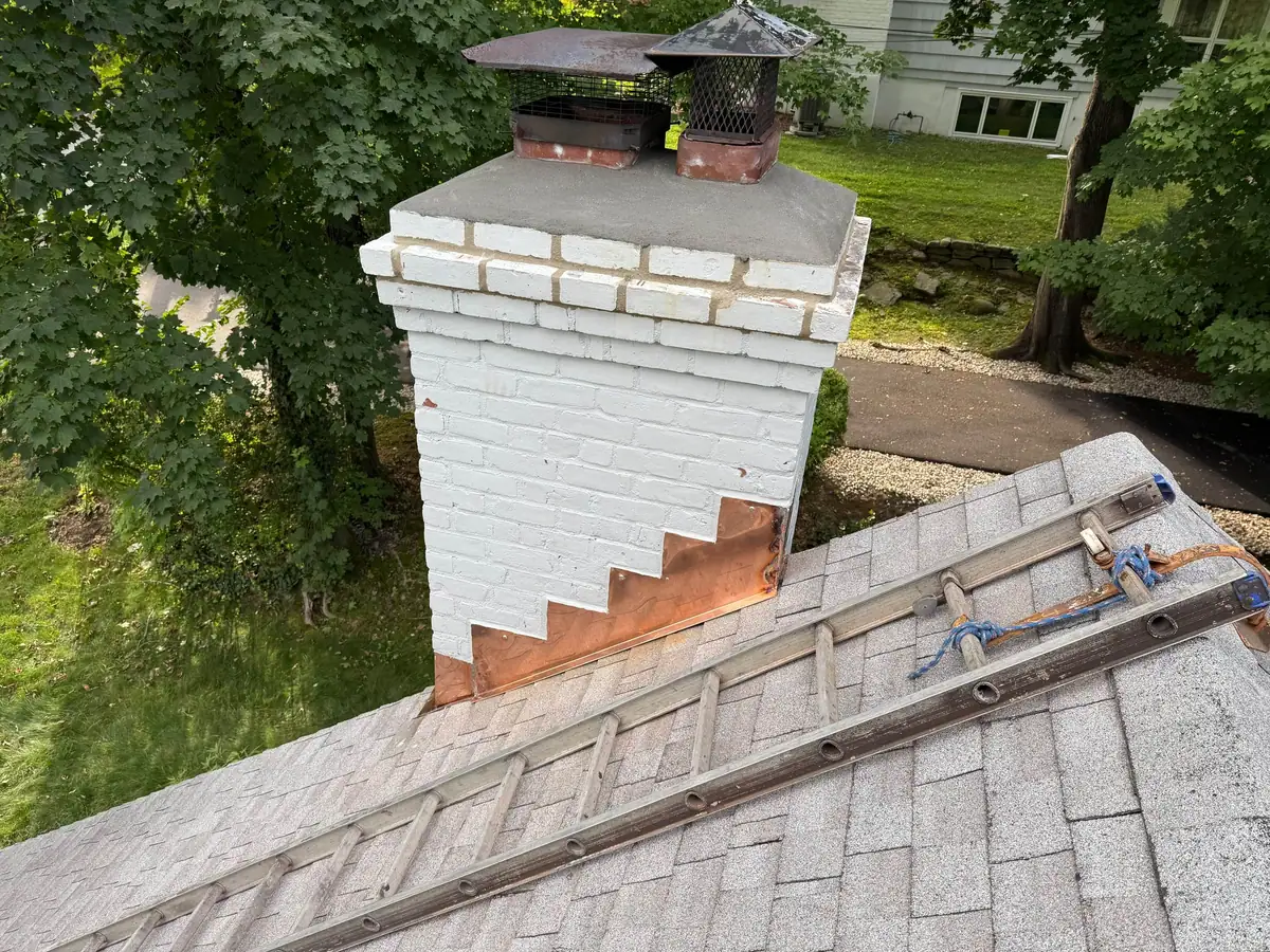 Finished copper step flashing installed at the chimney